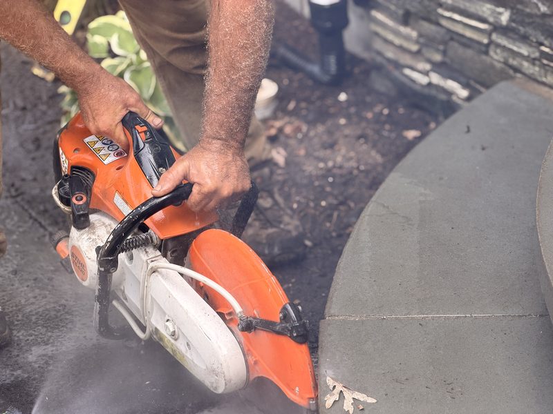A bluestone tread being wet-cut to the curve with a cut-off saw