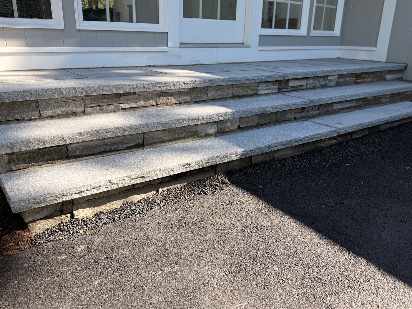 Low view along the granite treads showing the rock-faced edge and the stone risers behind it