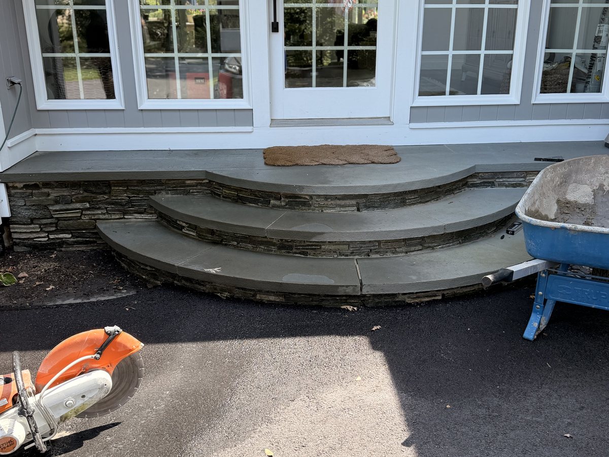 The curved bluestone flight that was at the door, three radiused treads stepping down to the drive