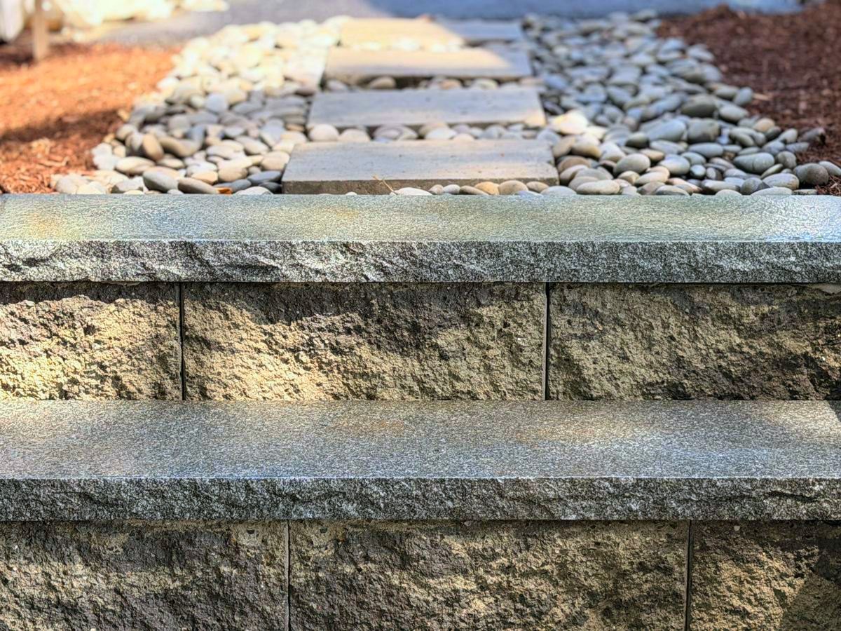 Granite treads with stepping stones set through washed stone beyond them