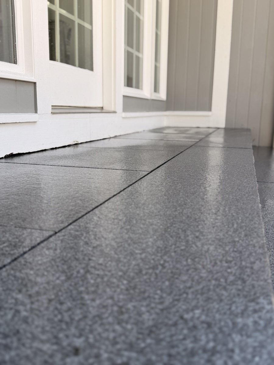 Along the landing at eye level, the joint between slabs tight and the thermal finish catching the light
