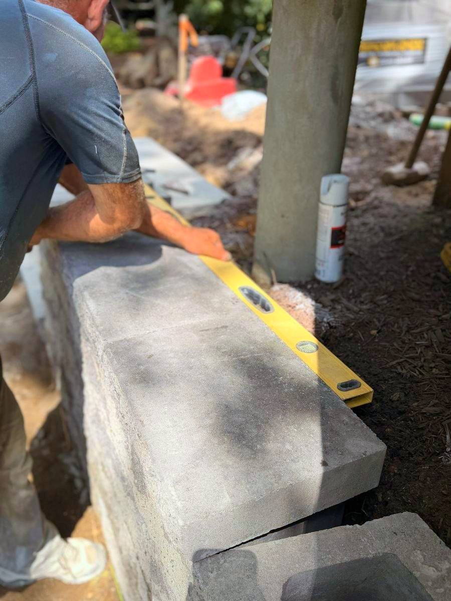 Levelling a cap stone along the wall