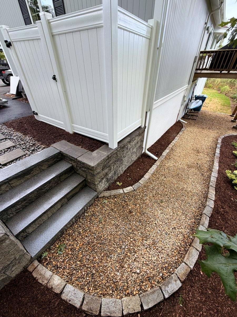 Granite steps with a cobble edge sweeping washed stone around them in a single curve