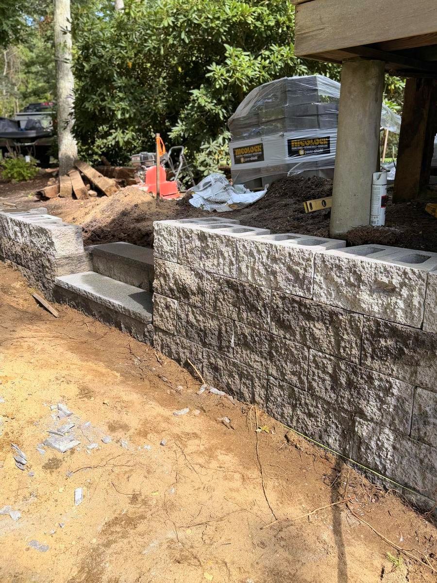 Block retaining wall with granite steps, seen down the run